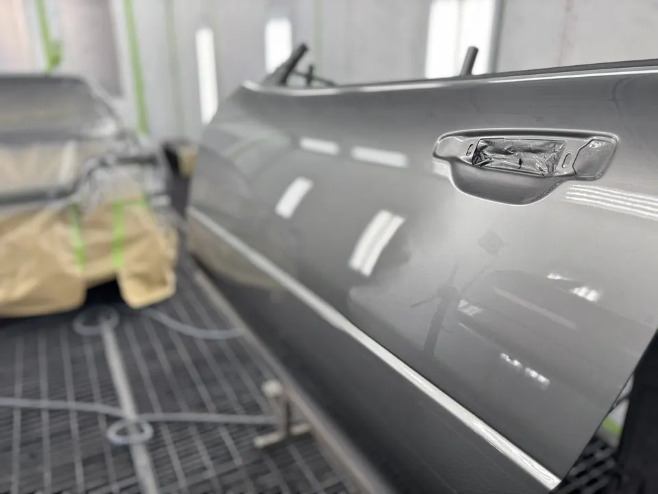 Nahaufnahme einer Autotürgriff mit unscharfem Werkstatthintergrund, Schutzfolie und LED-Beleuchtung
